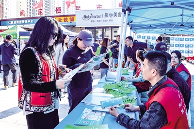 活動現場,居民圍在招聘展板前仔細查看崗位信息。韓堃攝